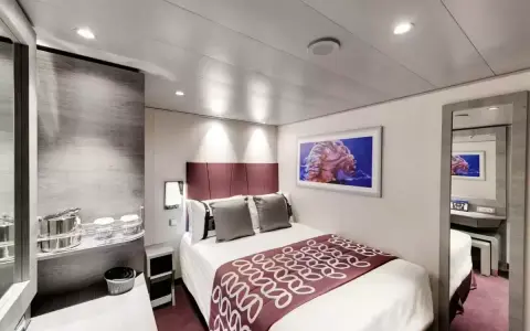 Cabina MSC Grandiosa ponte 8: letto matrimoniale, quadro con medusa, specchio e arredi moderni.