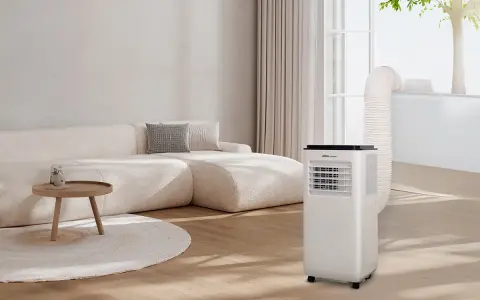 Un aire acondicionado portátil con tubo de escape conectado a la ventana, parte de unas modernas instalaciones hvac, en un salón con sofá beige.