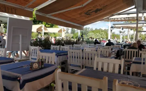 Uroczy ogródek restauracyjny w Larnace z niebiesko-białymi obrusami. Idealne miejsce, by dowiedzieć się, co i gdzie zjeść w Larnace.