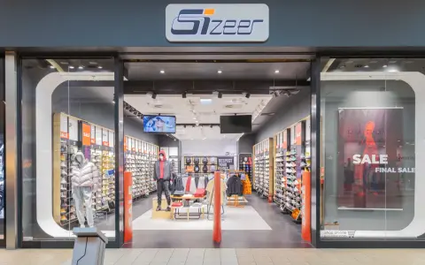 Sklep Sizeer z butami i odzieżą sportową, z manekinami i ekspozycją produktów.