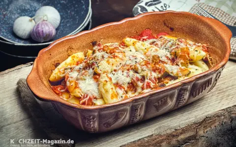 Ein köstlicher italienischer Auflauf mit geschmolzenem Käse und Tomatensauce in einer rustikalen Auflaufform.