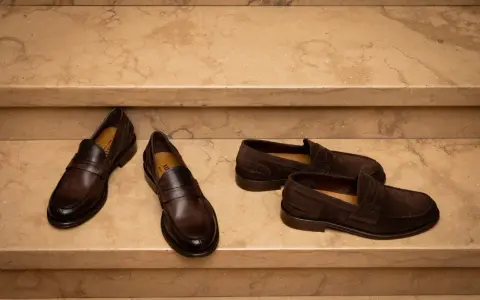 Due paia di mocassini uomo marroni, uno in pelle lucida e l'altro in camoscio, perfetti per un outfit elegante.