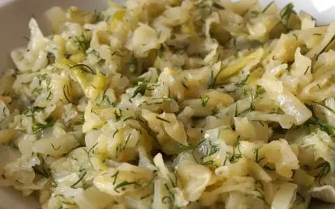 Pyszna, duszona kapusta na krótko z koperkiem, podana w białej misce.