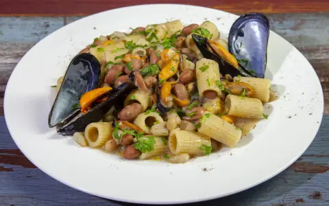 Piatto di pasta fagioli e cozze, con rigatoni, fagioli borlotti e cannellini, cozze nere e prezzemolo tritato.