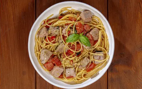 Spaghetti al tonno, un classico profumato, come la spaghetti al tonno ricetta della nonna, con pomodorini e basilico fresco.
