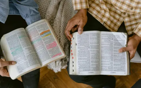 Dwie osoby czytają Biblię, zaznaczając ważne cytaty. Widać fragmenty z Księgi Przysłów.
