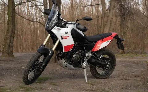 Yamaha Tenere 700 waga idealna na wyprawy. Motocykl stoi na leśnej ścieżce, gotowy do przygody.