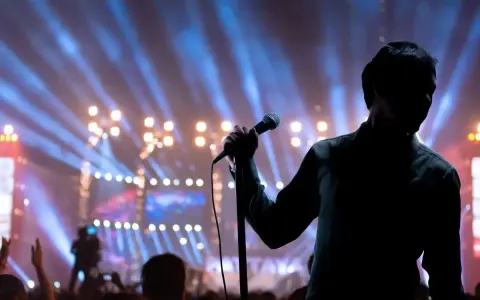 Cantante sul palco con microfono, luci sfocate e folla. Il **take on me significato** è l'essenza di un'esibizione che cattura l'anima.