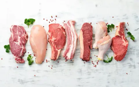 Varietà di carni: maiale, pollo e manzo. Carne bianca e rossa, con pepe rosa e prezzemolo.