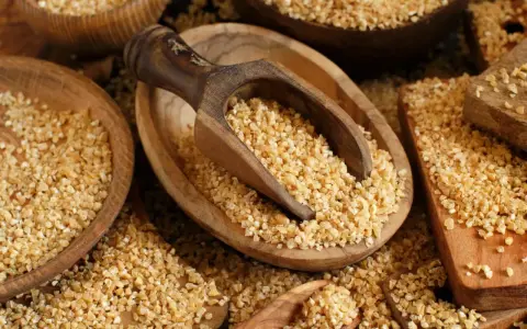 Kasza bulgur w drewnianych misach, gotowa do spożycia. Niski indeks glikemiczny sprawia, że jest zdrowym wyborem.