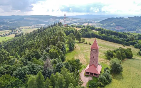 Wieża widokowa w górach zaprasza na podziwianie krajobrazu. W oddali widać maszt telekomunikacyjny.