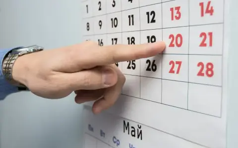 Palec wskazuje datę 20 na kalendarzu. Czas na podjęcie decyzji o okresie wypowiedzenia umowy o pracę.