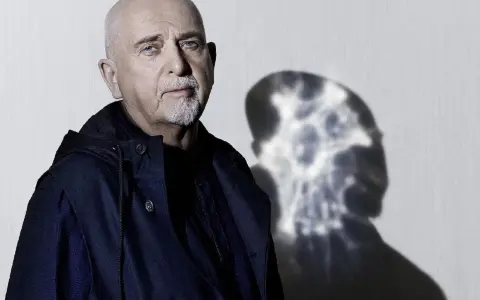 Peter Gabriel z charakterystycznym cieniem na ścianie, zapowiadający nową płytę.
