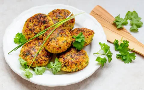Goldbraune Hirse-Patties, garniert mit frischen Kräutern, sind ein köstliches Beispiel für Hirse Gerichte.