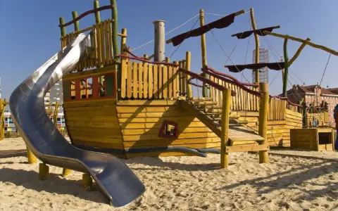 Parque infantil con barco de madera y tobogán, ideal para la vitoria con niños. ¡Aventuras piratas garantizadas!