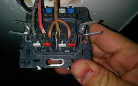 Branchement interrupteur avec voyant lumineux en cours. Fils électriques connectés aux bornes.
