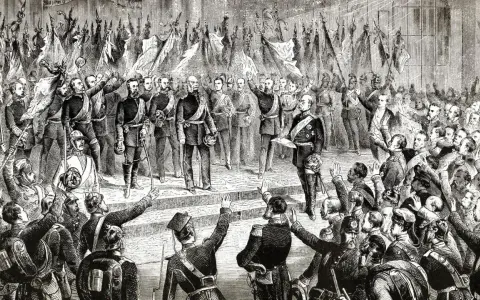 Eine jubelnde Menge winkt Fahnen. Im Vordergrund stehen Männer in Uniform, die an die negative Integration Bismarcks erinnern.