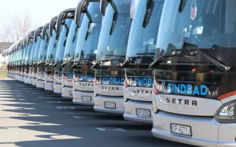 Rząd białych autokarów Sindbad Setra gotowych do podróży z Niemiec do Polski.