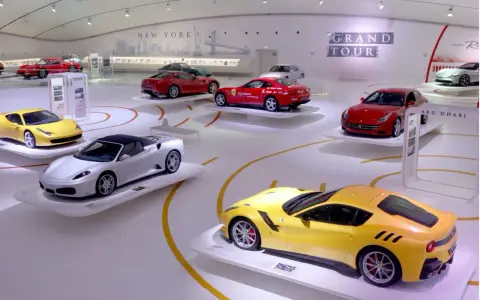 W muzeum Ferrari w Maranello lub w Modenie, na wystawie "Grand Tour", prezentowane są lśniące modele, w tym żółty i srebrny kabriolet.