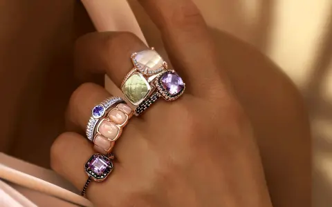 Dita adornate con anelli che esaltano il loro fascino, un vero **materiale prezioso** che cattura la luce.