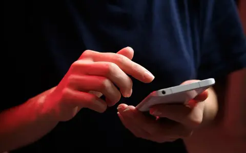 Dłonie z czerwonym podświetleniem obsługują smartfon, być może ustawiając **direct debit** na rachunki.