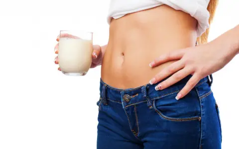 Donna con bicchiere di latte, un aiuto per sapere cosa bere la sera per andare di corpo.