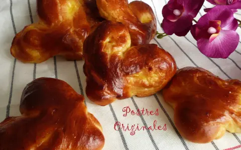 Pan de leche dorado y esponjoso, con forma de corazón, junto a orquídeas moradas. ¡Postres originales para disfrutar!