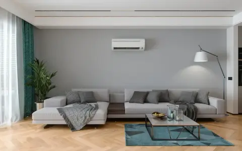 Salon moderne avec canapé gris, tapis bleu, et climatisation souffle froid en mode chauffage.