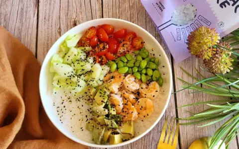 Délicieuse recette salade asiatique : riz, crevettes, avocat, concombre, tomates cerises et edamame, parsemée de graines de sésame.