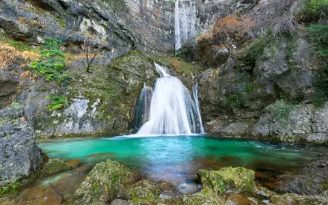 Impresionantes cascadas en Albacete, con agua turquesa cayendo por rocas cubiertas de musgo. Un paisaje natural de ensueño.
