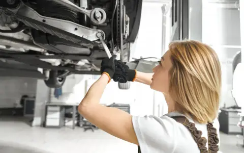 Mechanik sprawdza podwozie auta, szukając objawów uszkodzonego amortyzatora.