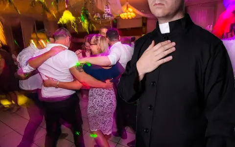 Ksiądz z ręką na sercu obserwuje tańczących ludzi. Czy w wielkim poście można tańczyć?