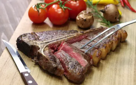 Una succulenta bistecca alla fiorentina, tagliata e pronta per essere gustata. Perfetta per scoprire dove mangiare la fiorentina a Firenze.
