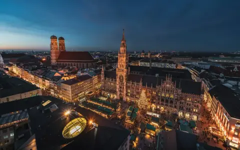 Beleuchtetes Rathaus und Christkindlmarkt in München, ein perfekter Ort für Munich Sightseeing bei Nacht.