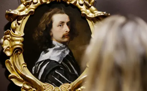 Portret mężczyzny w złotej ramie, jedno z dzieł Antoona van Dycka, oglądany przez widza.