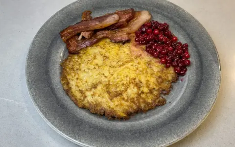 En gyllene raggmunk med knaperstekt bacon och rårörda lingon. Ett klassiskt raggmunk recept som smakar ljuvligt.