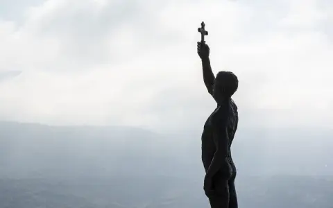 Sylwetka mężczyzny z krzyżem w dłoni, symbolizująca walkę o jedność wiary, nawiązuje do przyczyn schizmy wschodniej.