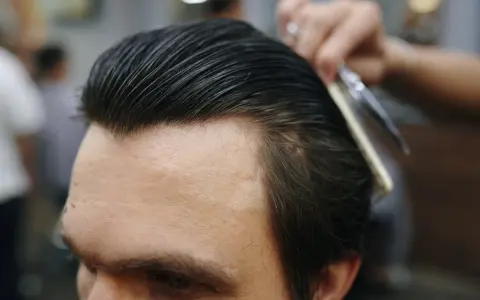 Profesjonalny styling włosów: grzebień i nożyczki w akcji, tworząc idealną fryzurę.