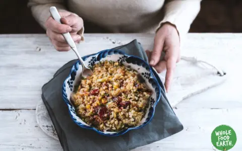 Un bol de freekeh recette, garni de canneberges et de légumes, prêt à être dégusté.