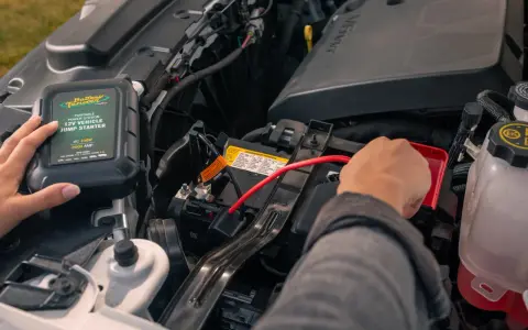 A person connects a Battery Tender jump starter to a car battery. This answers the question: do jump starters come charged?