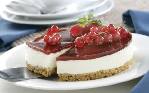 Tarta de queso Philadelphia con frutos rojos y gelatina de fresa, lista para servir.