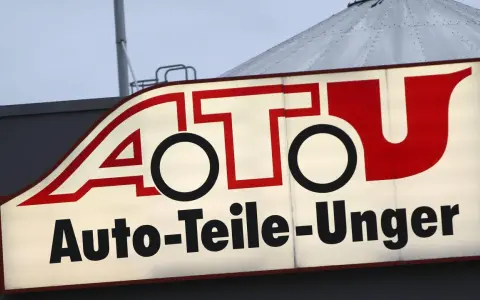 Leuchtreklame von A.T.U. Auto-Teile-Unger mit rotem Schriftzug und weißem Hintergrund.