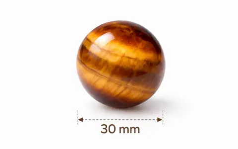 Piłka z tygrysiego oka, 30 mm. Kamień ten znany jest ze swoich właściwości ochronnych i dodawania pewności siebie.