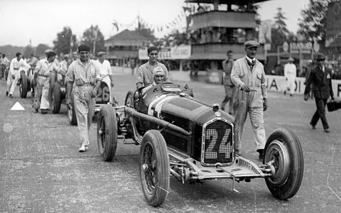Tazio Nuvolari, leggenda dell'automobilismo, con la sua Alfa Romeo numero 24, pronto a sfrecciare.