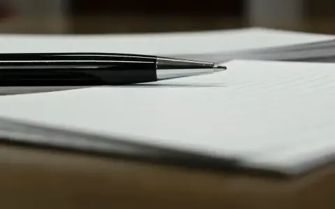 Czarny długopis leży na papierze, gotowy do podpisania ważnego dokumentu, np. pełnomocnictwa.