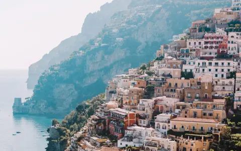 Colorful buildings cascade down a cliffside to the sea, a picturesque scene perfect for a 3 month Europe itinerary.