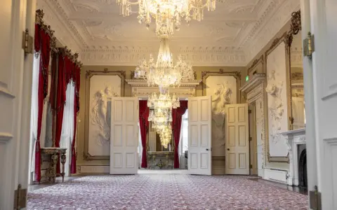 Ett elegant rum med kristallkronor och röda draperier i Dicksonska palatset.