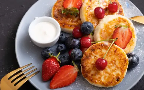 Pyszne placuszki z twarogu, idealne na śniadanie z airfryer, podane z owocami i śmietaną.