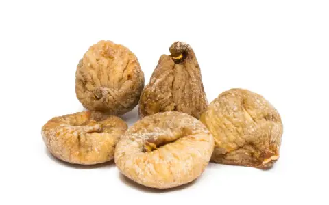 Fünf getrocknete Feigen, die zeigen, wie gesund Feigen sind. Sie sind leicht mit Zucker bestäubt und liegen auf weißem Hintergrund.