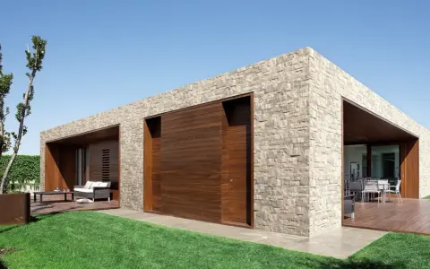 Moderna casa con facciate in pietra e inserti in legno. Un'oasi di design contemporaneo.